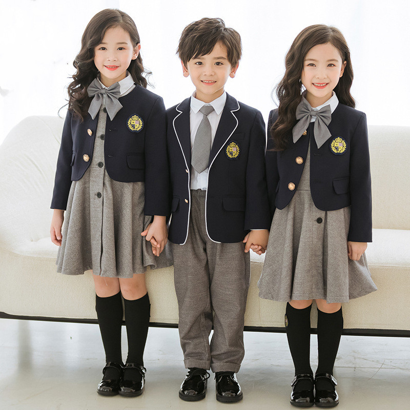 Three students in formal gray and navy uniforms with gold buttons and school emblems